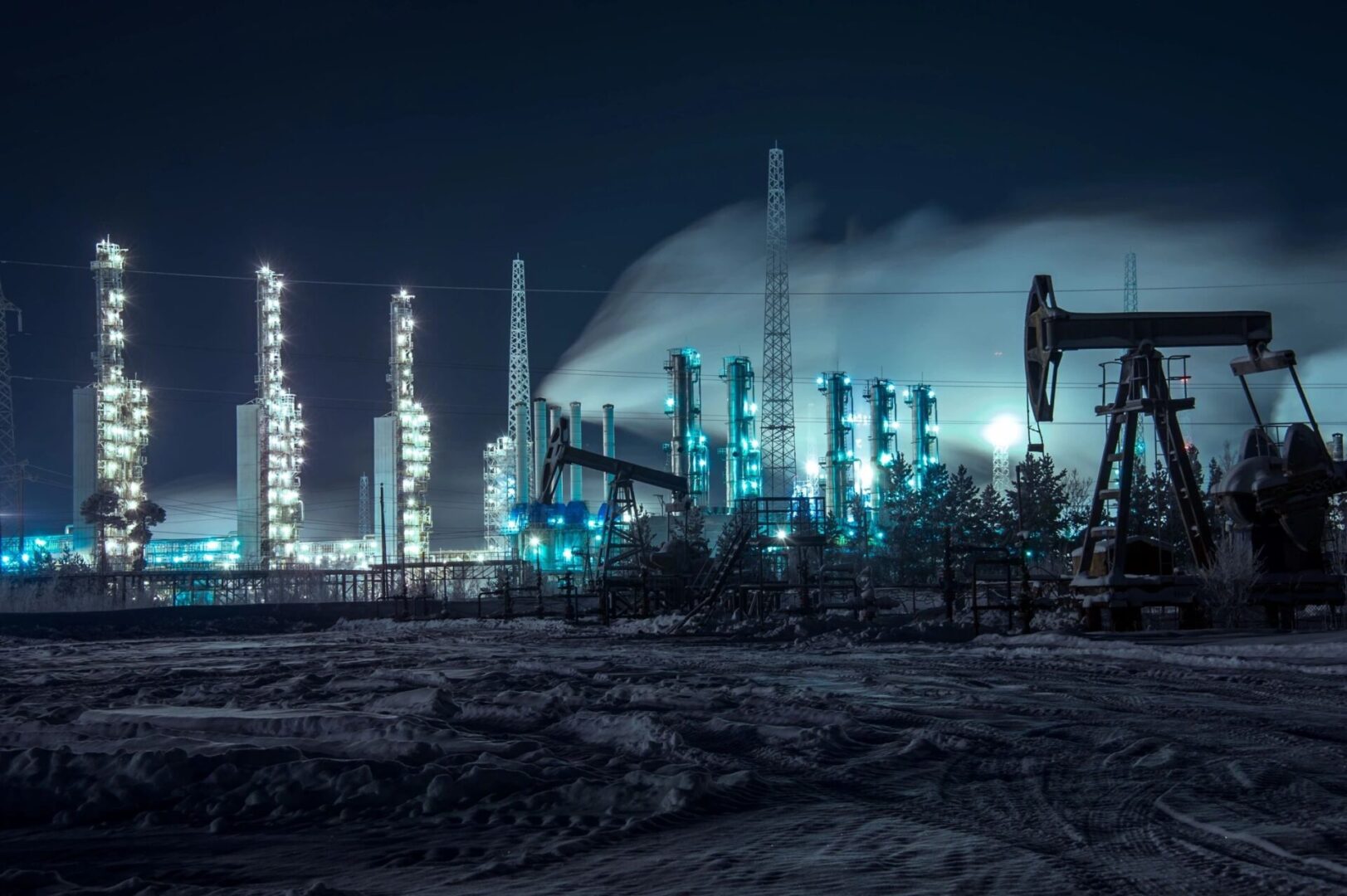 A large oil field with many pipes and some pumps.